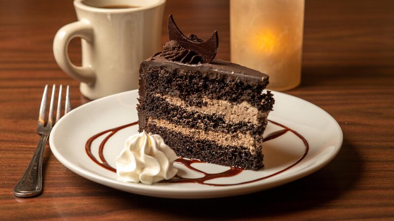 Chocolate cake with whipped cream and drizzled chocolate sauce
